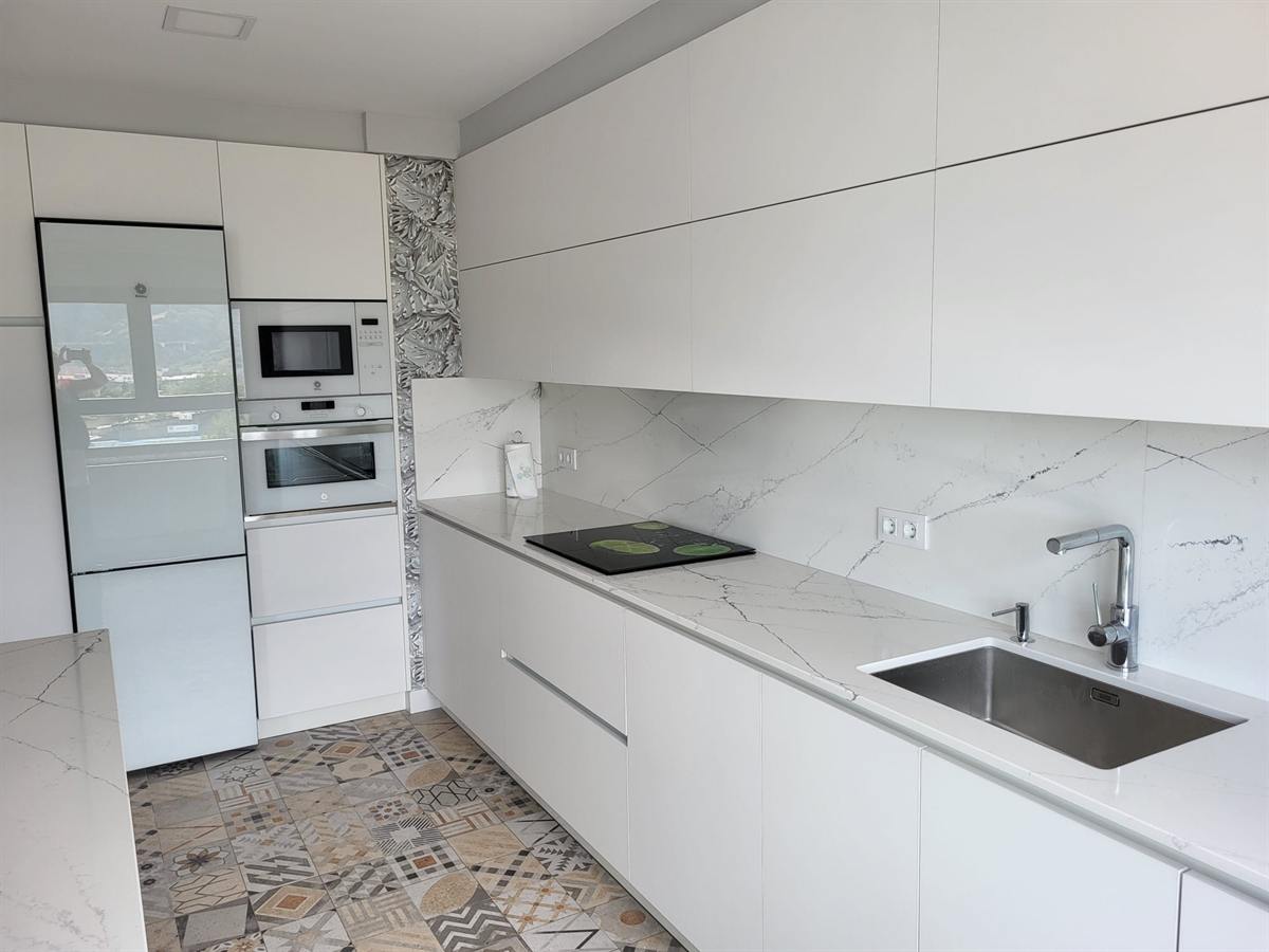 Cocina en blanco con encimera y frente de mármol veteado