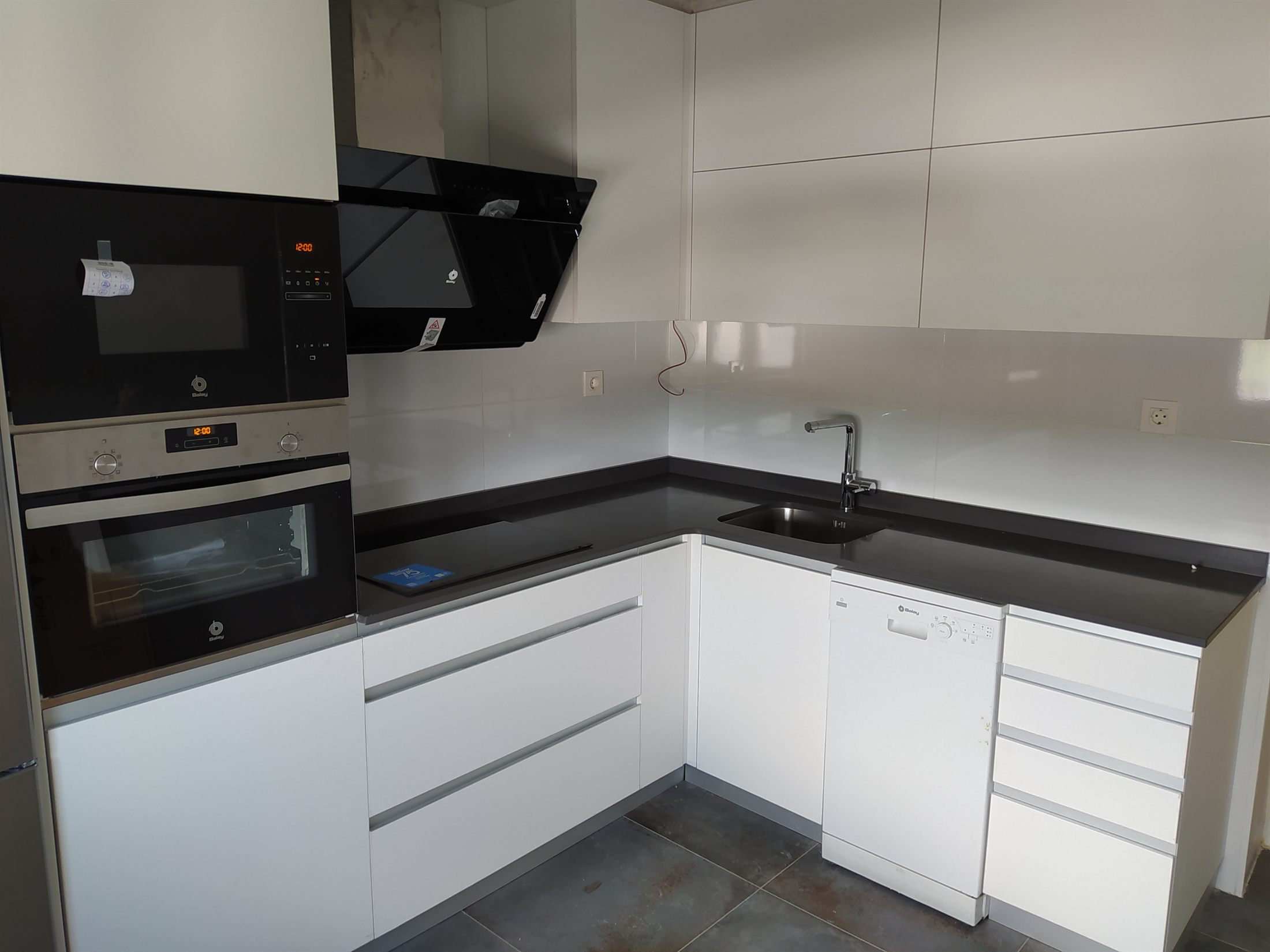 Cocina real instalada por Decocina, con encimera de gran formato y electrodomésticos integrados